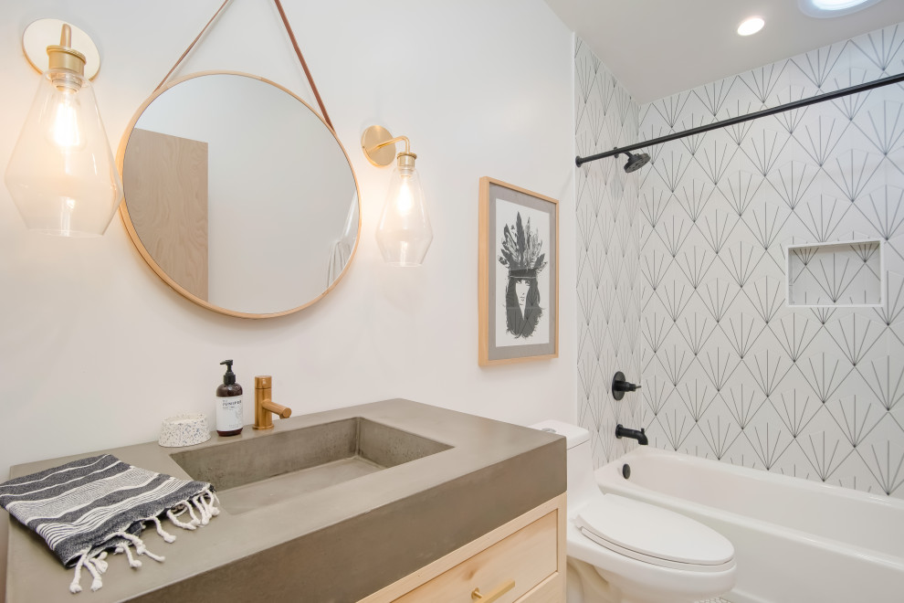 Bild på ett mellanstort retro grå grått badrum för barn, med släta luckor, vita skåp, en dusch i en alkov, vit kakel, cementkakel, vita väggar, klinkergolv i keramik, ett avlångt handfat, bänkskiva i betong och vitt golv