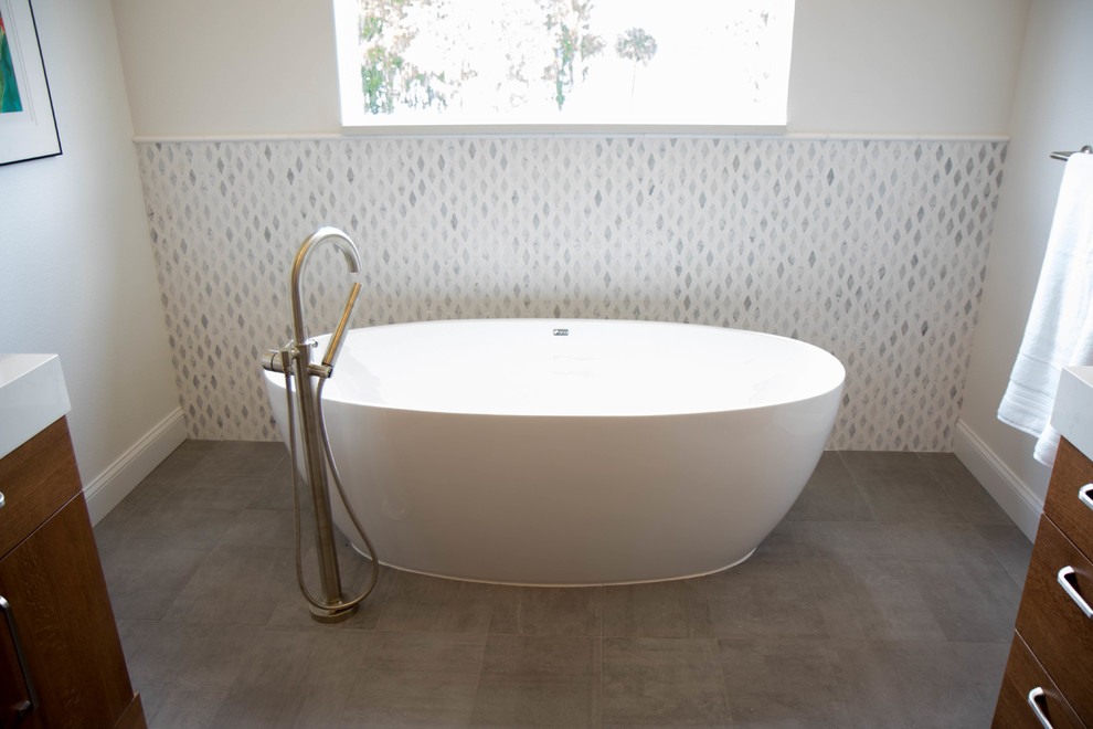 Réalisation d'une salle de bain principale vintage en bois brun avec un placard à porte plane, une baignoire indépendante, un carrelage blanc, du carrelage en marbre, un sol en carrelage de porcelaine, un plan de toilette en quartz modifié, un sol gris et un plan de toilette blanc.