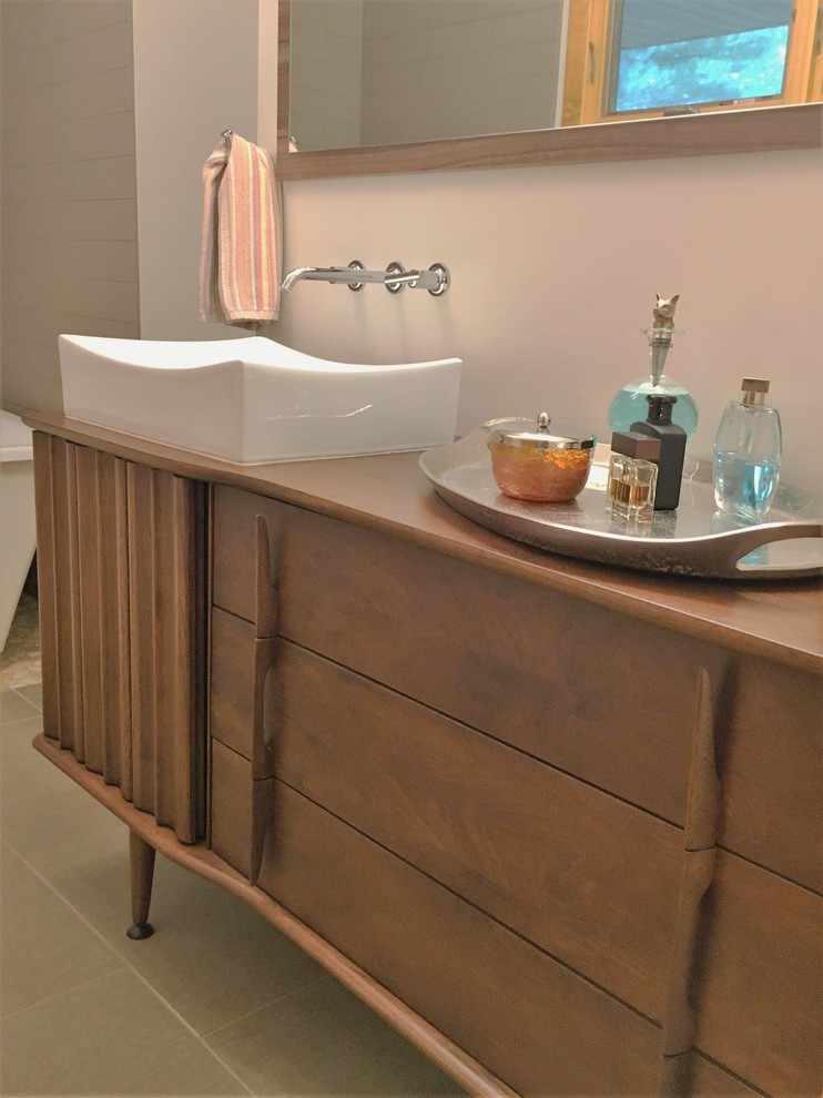Example of a mid-sized mid-century modern master freestanding bathtub design in Other with a vessel sink