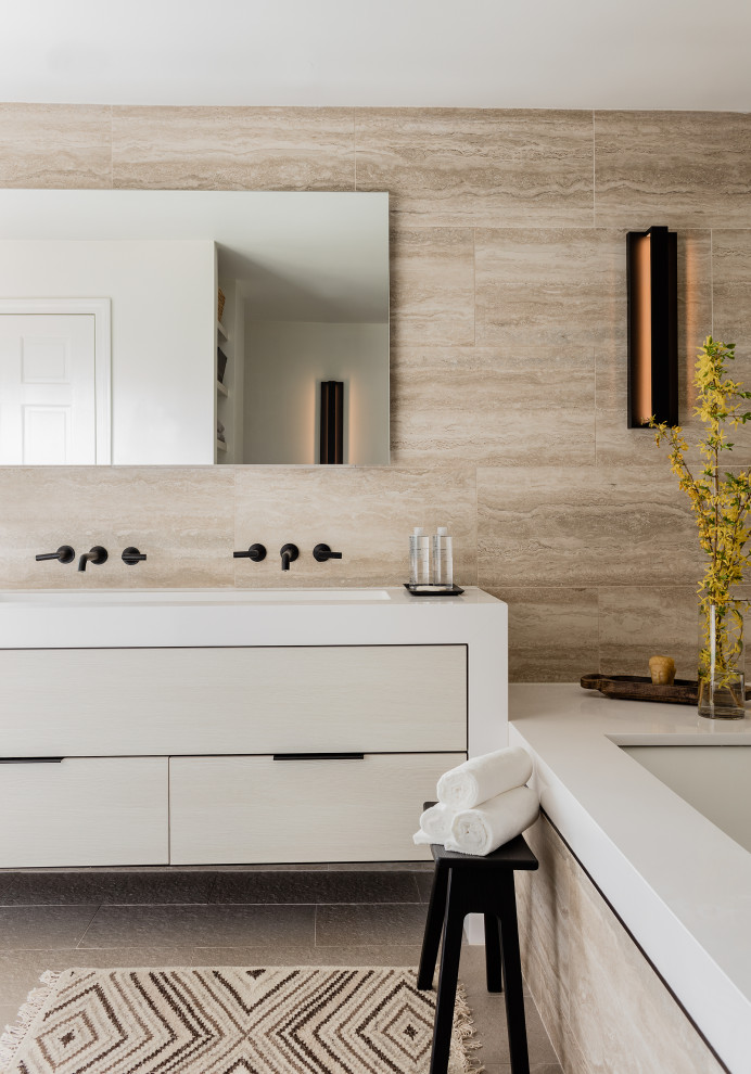 На фото: ванная комната в современном стиле с плоскими фасадами, серыми фасадами, полновстраиваемой ванной, коричневой плиткой, врезной раковиной, серым полом, белой столешницей, тумбой под две раковины и подвесной тумбой с