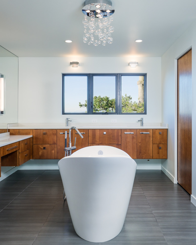 This is an example of a contemporary bathroom in Seattle with flat-panel cabinets, medium wood cabinets and a freestanding bath.
