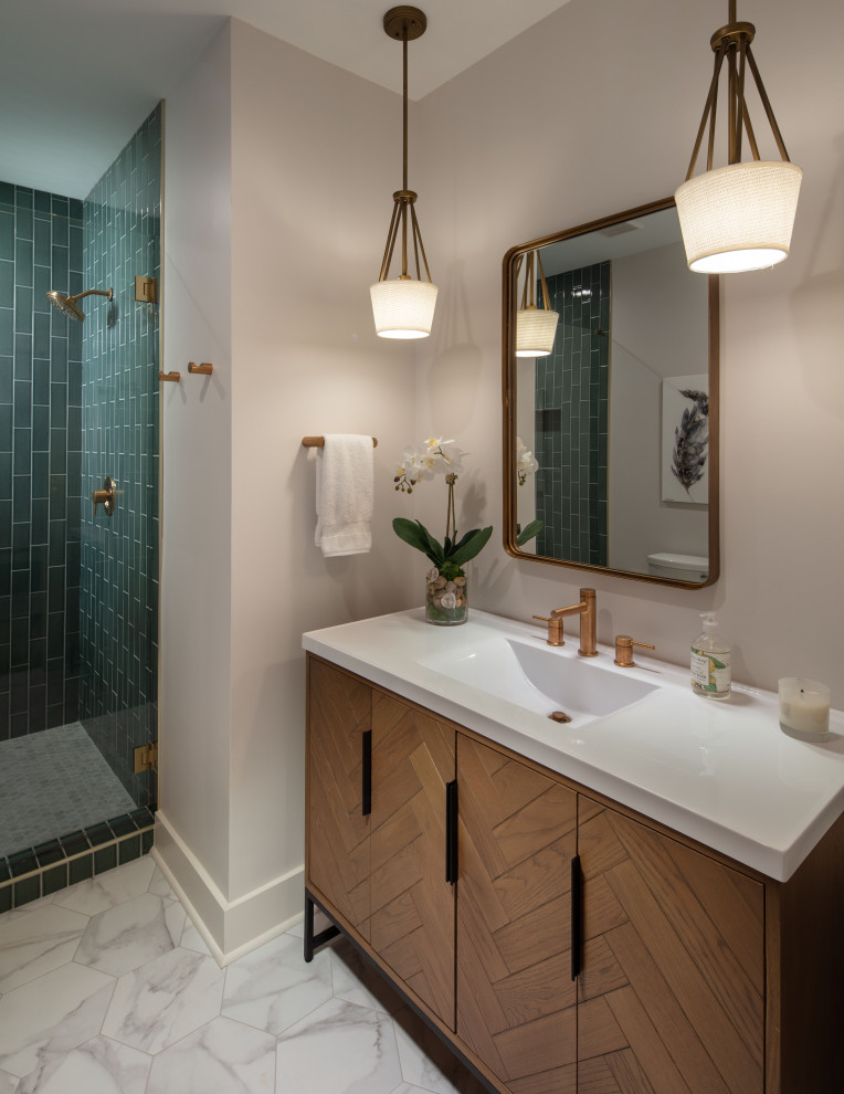 Стильный дизайн: ванная комната среднего размера в стиле неоклассика (современная классика) с фасадами островного типа, коричневыми фасадами, душем без бортиков, унитазом-моноблоком, зеленой плиткой, керамогранитной плиткой, серыми стенами, полом из керамогранита, врезной раковиной, мраморной столешницей, серым полом, душем с распашными дверями, белой столешницей, тумбой под одну раковину и напольной тумбой - последний тренд