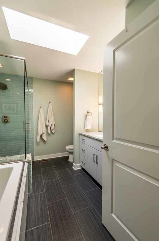 Aménagement d'une salle de bain principale et grise et blanche contemporaine de taille moyenne avec un placard à porte plane, des portes de placard blanches, une baignoire indépendante, une douche d'angle, WC séparés, un carrelage vert, un carrelage métro, un mur beige, un sol en ardoise, un lavabo posé, un plan de toilette en marbre, un sol gris, une cabine de douche à porte battante, un plan de toilette gris, meuble simple vasque, meuble-lavabo encastré et un plafond en papier peint.