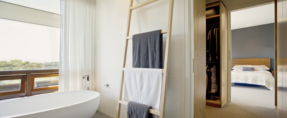 Exempel på ett stort modernt en-suite badrum, med ett fristående badkar, vit kakel, vita väggar och kalkstensgolv