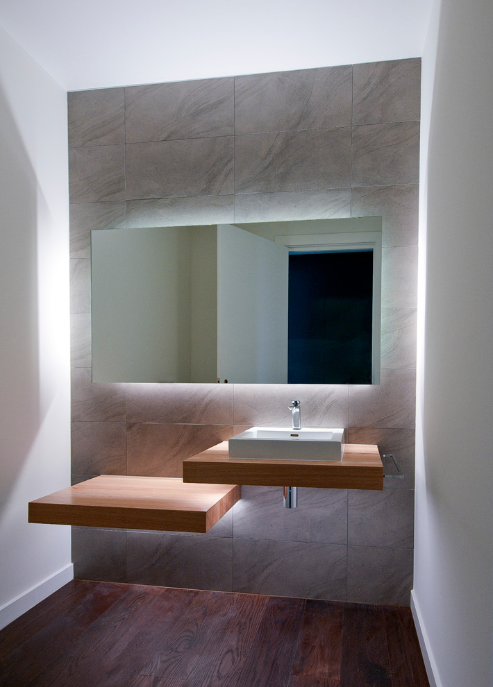 Modelo de cuarto de baño moderno pequeño con baldosas y/o azulejos grises, baldosas y/o azulejos de cerámica, paredes blancas, suelo de madera oscura y encimera de madera