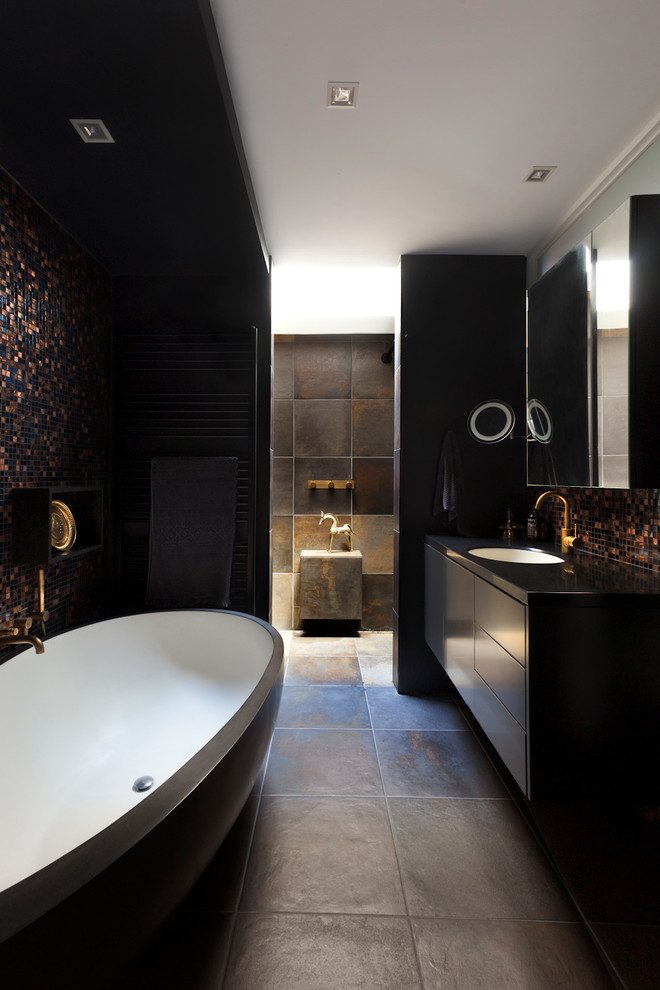 Foto på ett mellanstort funkis en-suite badrum, med ett undermonterad handfat, släta luckor, svarta skåp, bänkskiva i kvarts, ett fristående badkar, en öppen dusch, keramikplattor, svarta väggar och klinkergolv i keramik