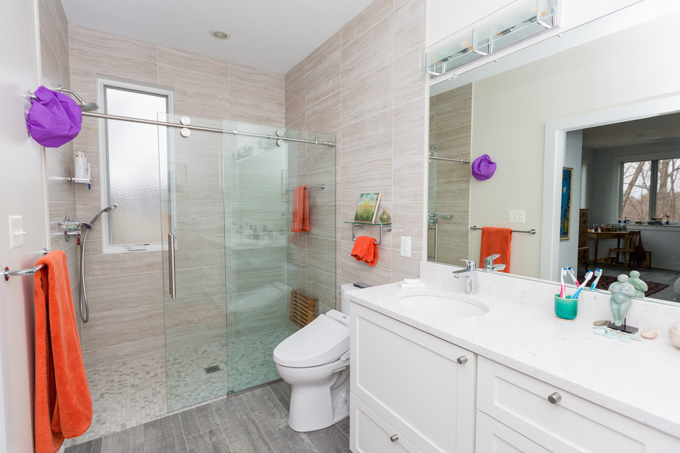 Modern inredning av ett mellanstort vit vitt badrum med dusch, med skåp i shakerstil, vita skåp, en dusch i en alkov, en bidé, beige kakel, stenkakel, vita väggar, klinkergolv i porslin, ett undermonterad handfat, bänkskiva i kvarts, grått golv och dusch med skjutdörr