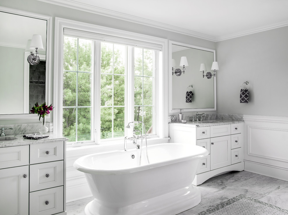 This is an example of a classic grey and white ensuite bathroom in Chicago with a submerged sink, recessed-panel cabinets, white cabinets, marble worktops, a freestanding bath, grey tiles, stone tiles, grey walls and marble flooring.