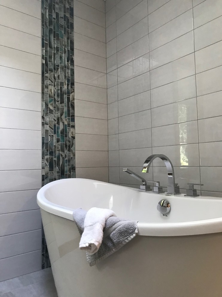 Cette image montre une grande salle de bain principale vintage avec une baignoire indépendante, une douche à l'italienne, un carrelage gris, des carreaux de céramique, un mur gris, un sol en carrelage de porcelaine, un lavabo encastré, un plan de toilette en quartz modifié, un sol gris, aucune cabine et un plan de toilette blanc.
