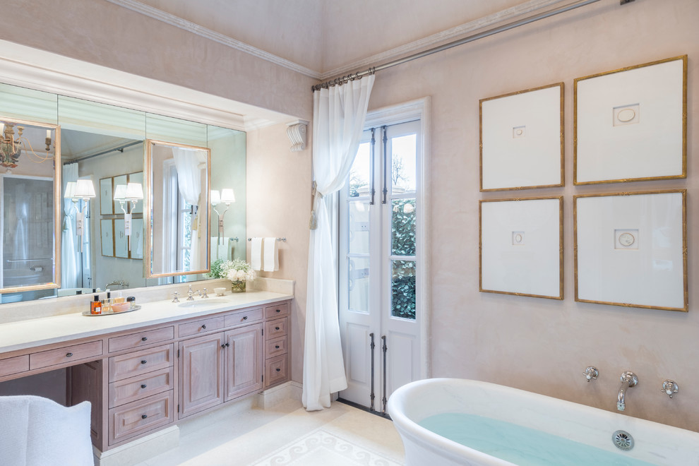 Exemple d'une salle de bain principale méditerranéenne en bois clair avec un placard avec porte à panneau surélevé, un mur beige, un lavabo encastré, un sol blanc et un plan de toilette blanc.