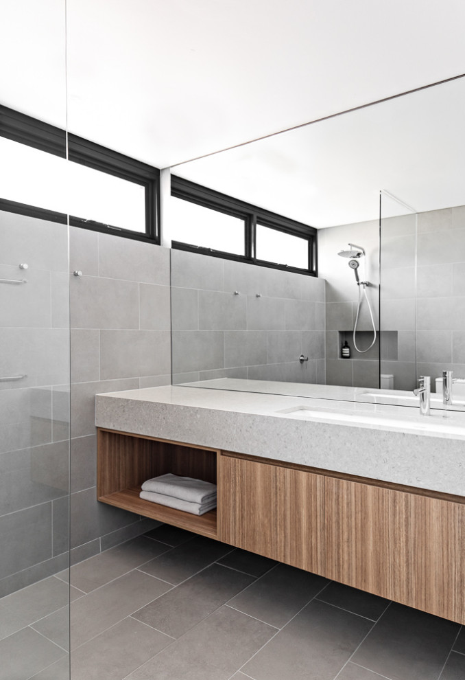 Small contemporary ensuite wet room bathroom in Sydney with brown cabinets, a one-piece toilet, grey tiles, porcelain tiles, grey walls, porcelain flooring, a submerged sink, engineered stone worktops, grey floors, an open shower, grey worktops, a single sink and a floating vanity unit.