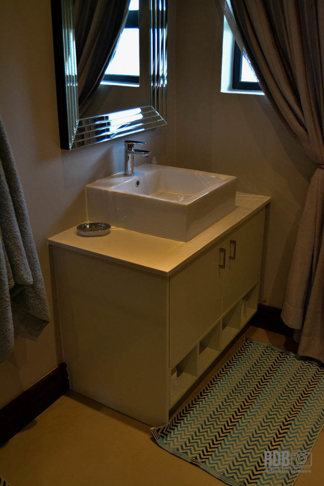 Small modern ensuite bathroom in Other with flat-panel cabinets, concrete flooring, a console sink, engineered stone worktops and white cabinets.