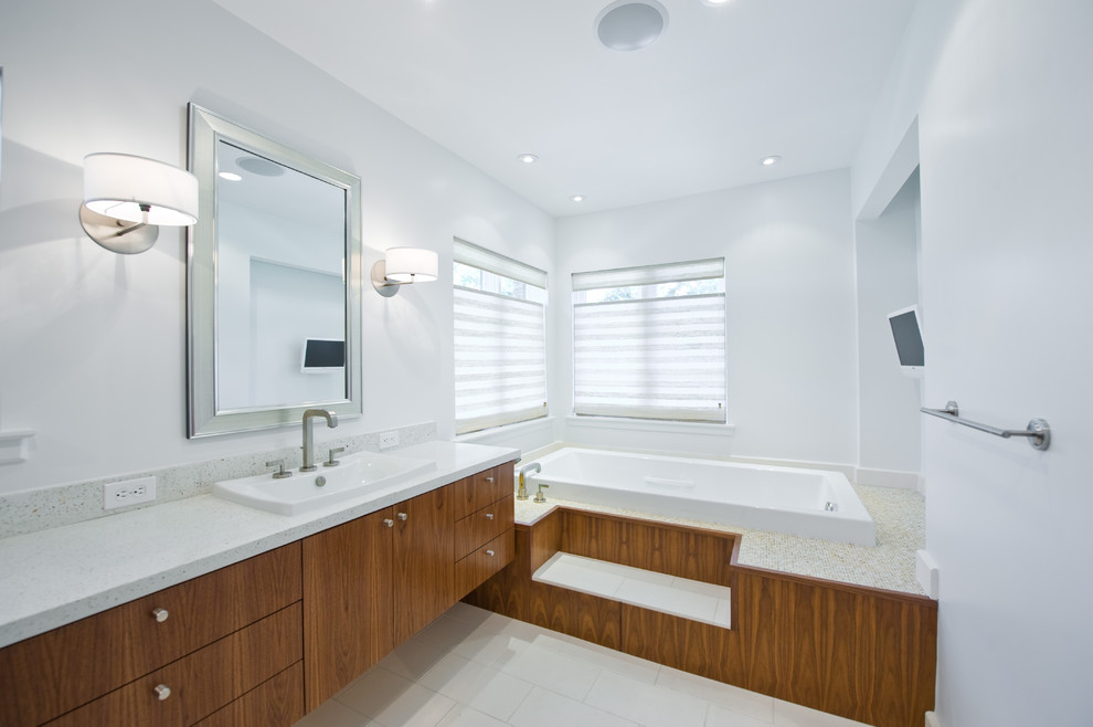 Ejemplo de cuarto de baño rectangular actual con lavabo encastrado, armarios con paneles lisos, puertas de armario de madera oscura y bañera encastrada
