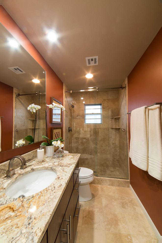 Foto på ett mellanstort vintage badrum med dusch, med ett undermonterad handfat, släta luckor, skåp i mörkt trä, granitbänkskiva, en dusch i en alkov, en toalettstol med hel cisternkåpa, beige kakel, stenkakel, orange väggar och marmorgolv