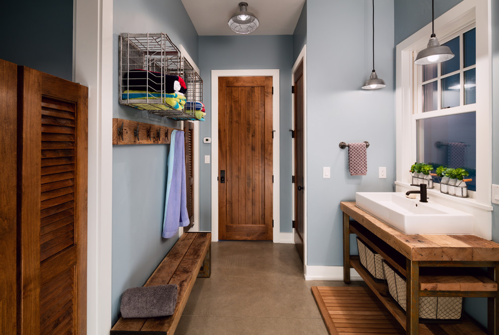 Diseño de cuarto de baño campestre de tamaño medio con armarios abiertos, paredes azules, lavabo de seno grande y encimera de madera