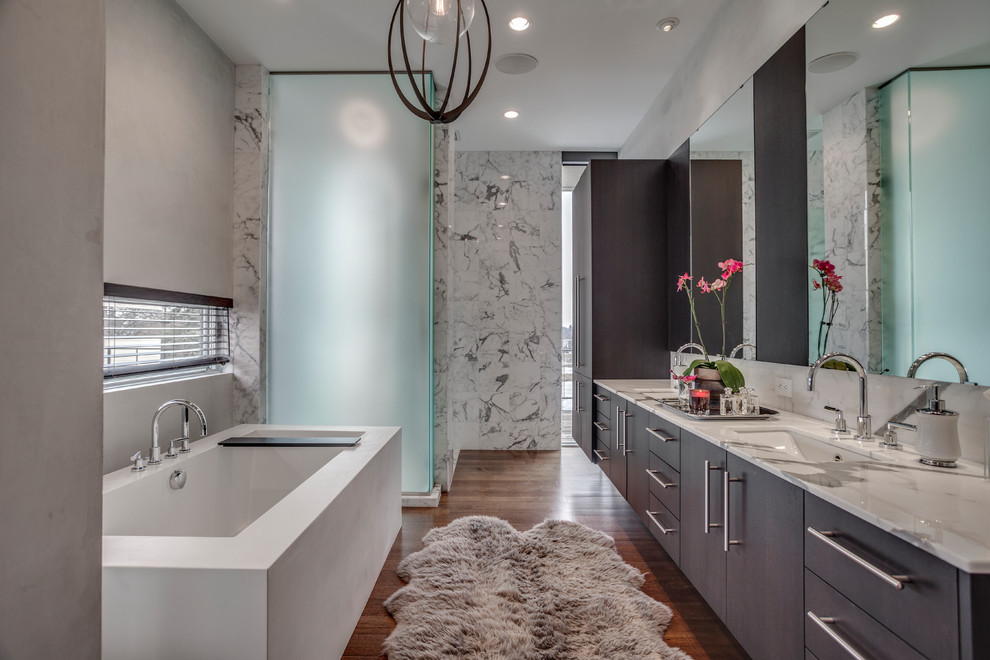 Exempel på ett modernt en-suite badrum, med släta luckor, skåp i mörkt trä, ett platsbyggt badkar, en dusch i en alkov, grå kakel, marmorkakel, mellanmörkt trägolv, ett integrerad handfat, marmorbänkskiva, brunt golv och dusch med gångjärnsdörr