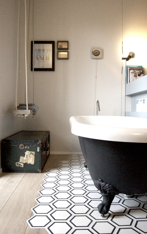 Foto di una stanza da bagno padronale industriale con vasca freestanding, piastrelle bianche, piastrelle in ceramica, pareti multicolore e pavimento con piastrelle in ceramica
