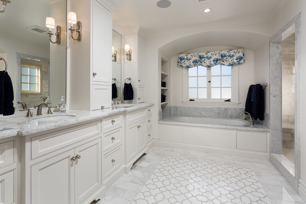 Cette image montre une salle de bain principale traditionnelle avec un placard avec porte à panneau encastré, des portes de placard blanches, une douche ouverte, WC à poser, un mur blanc, un lavabo encastré, un plan de toilette en marbre et aucune cabine.