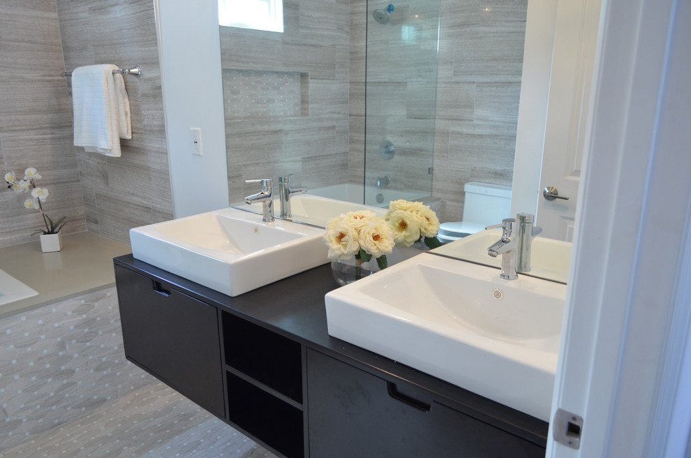 Medium sized traditional ensuite bathroom in Los Angeles with flat-panel cabinets, dark wood cabinets, a freestanding bath, an alcove shower, a one-piece toilet, brown tiles, ceramic tiles, grey walls, ceramic flooring, a submerged sink, wooden worktops, brown floors, a hinged door and black worktops.