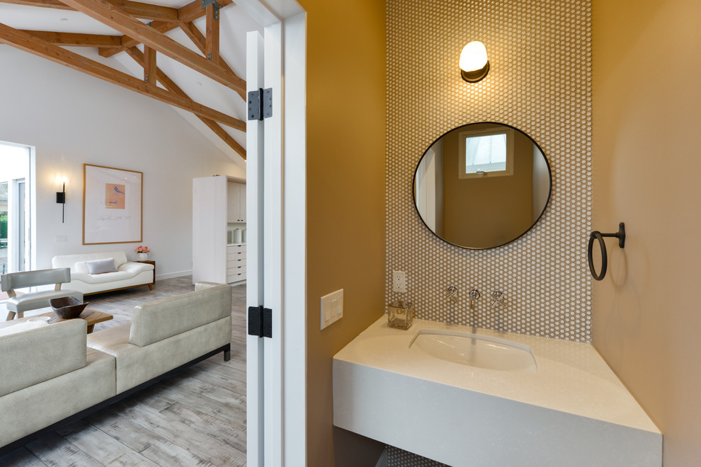 Exemple d'une petite salle de bain tendance avec des portes de placard blanches, un carrelage blanc, mosaïque, un mur marron, un lavabo encastré, un plan de toilette en quartz modifié et un plan de toilette blanc.