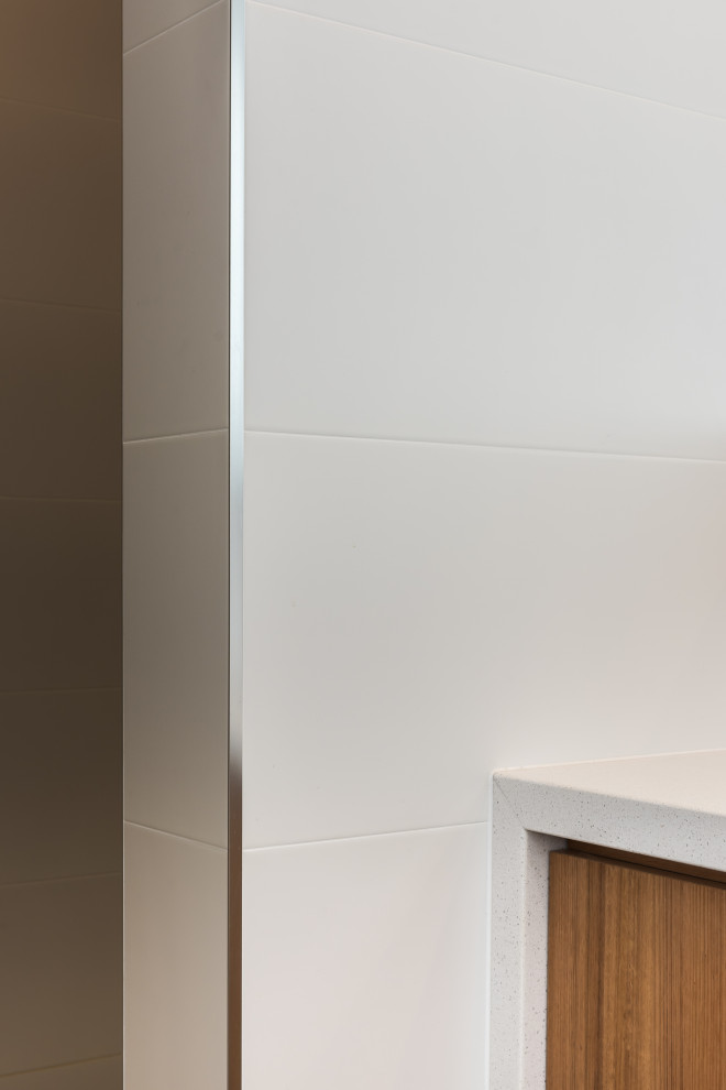 Design ideas for a medium sized urban family bathroom in Adelaide with flat-panel cabinets, medium wood cabinets, a built-in bath, an alcove shower, white tiles, ceramic tiles, white walls, cement flooring, a submerged sink, engineered stone worktops, grey floors, an open shower, white worktops, a wall niche, a single sink and a built in vanity unit.
