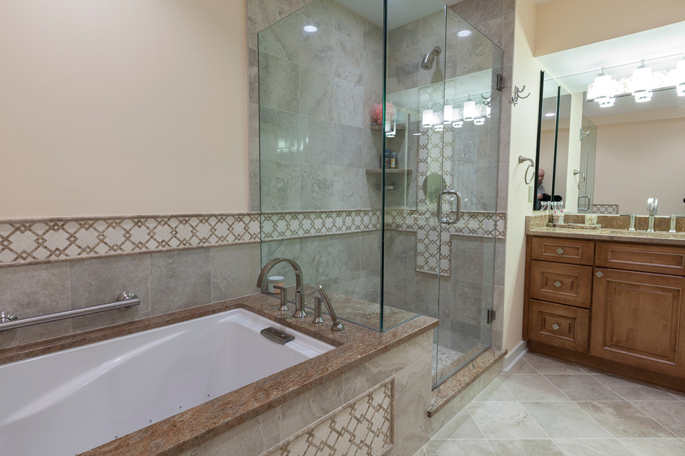 Small elegant master gray tile and porcelain tile porcelain tile and beige floor corner shower photo in Bridgeport with raised-panel cabinets, brown cabinets, an undermount tub, a two-piece toilet, beige walls, an undermount sink, granite countertops and a hinged shower door