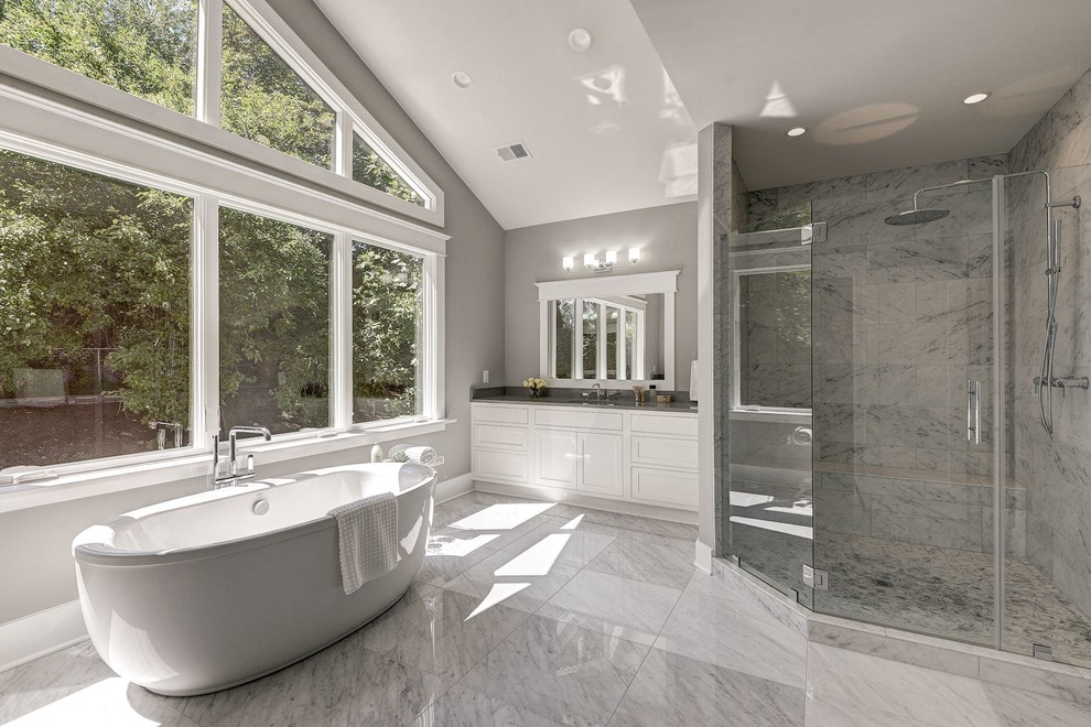 Inspiration for an expansive contemporary ensuite bathroom in DC Metro with shaker cabinets, white cabinets, a freestanding bath, a corner shower, grey walls, marble flooring, a submerged sink, engineered stone worktops, grey floors, a hinged door and grey worktops.