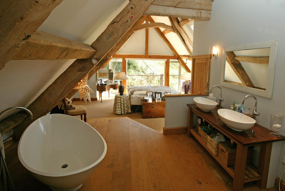 Idées déco pour une salle de bain principale campagne avec une vasque, un placard sans porte, un plan de toilette en bois, une baignoire indépendante, un carrelage beige, un mur blanc et un sol en bois brun.