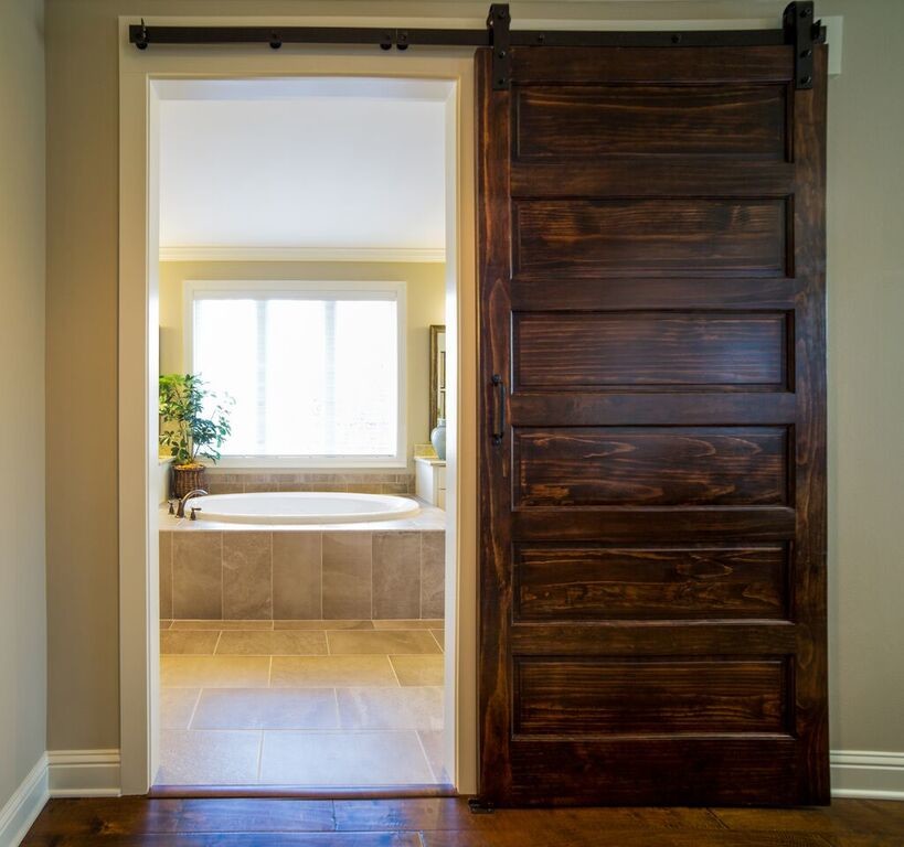 Cette image montre une salle de bain principale traditionnelle de taille moyenne avec une baignoire posée, un mur beige et un sol en travertin.