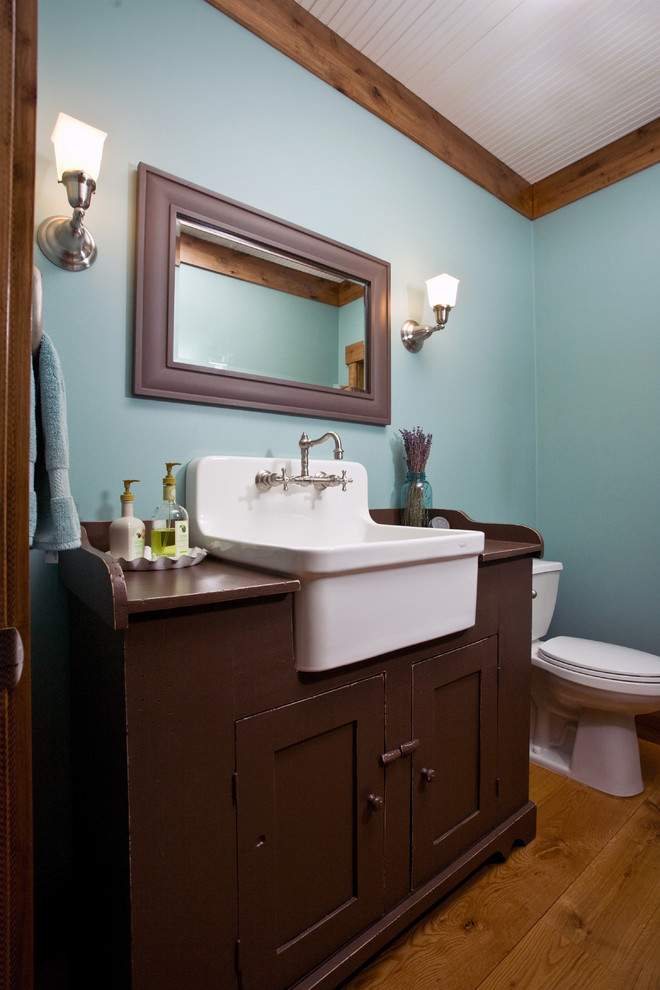 Example of a farmhouse bathroom design in Minneapolis with a drop-in sink, blue walls and dark wood cabinets