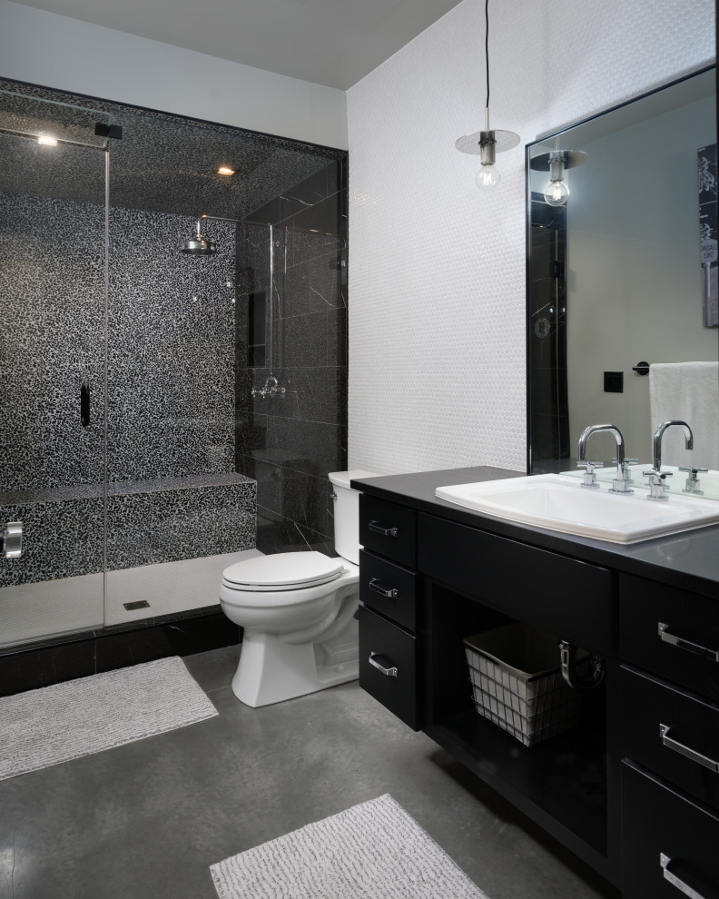 Пример оригинального дизайна: ванная комната в стиле лофт с плоскими фасадами, черными фасадами, душем в нише, раздельным унитазом, бетонным полом, душевой кабиной, накладной раковиной, серым полом, душем с распашными дверями, серой столешницей, сиденьем для душа, тумбой под одну раковину и встроенной тумбой