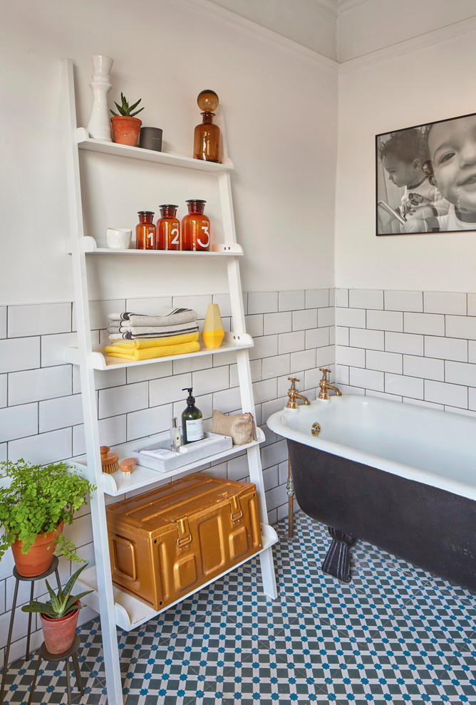 На фото: ванная комната в скандинавском стиле с открытыми фасадами, белыми фасадами, отдельно стоящей ванной, белой плиткой, плиткой кабанчик, белыми стенами, полом из керамической плитки и разноцветным полом с
