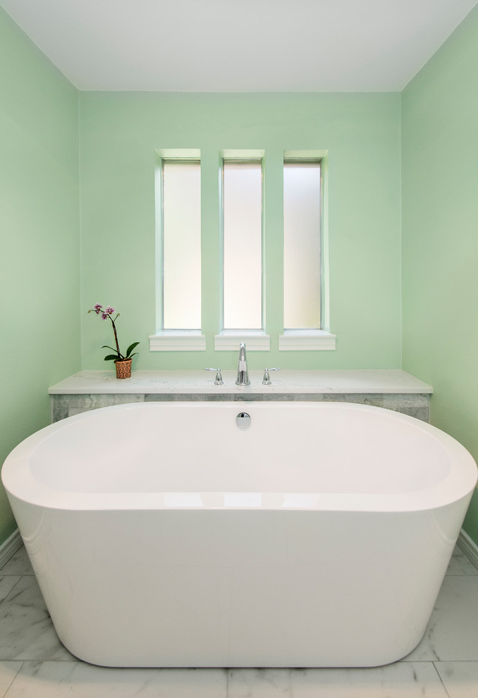 Cette photo montre une salle de bain principale chic de taille moyenne avec un placard avec porte à panneau surélevé, des portes de placard blanches, une baignoire indépendante, une douche d'angle, WC séparés, un carrelage blanc, du carrelage en marbre, un mur vert, un sol en carrelage de porcelaine, un lavabo encastré, un plan de toilette en quartz modifié, un sol blanc et une cabine de douche à porte battante.