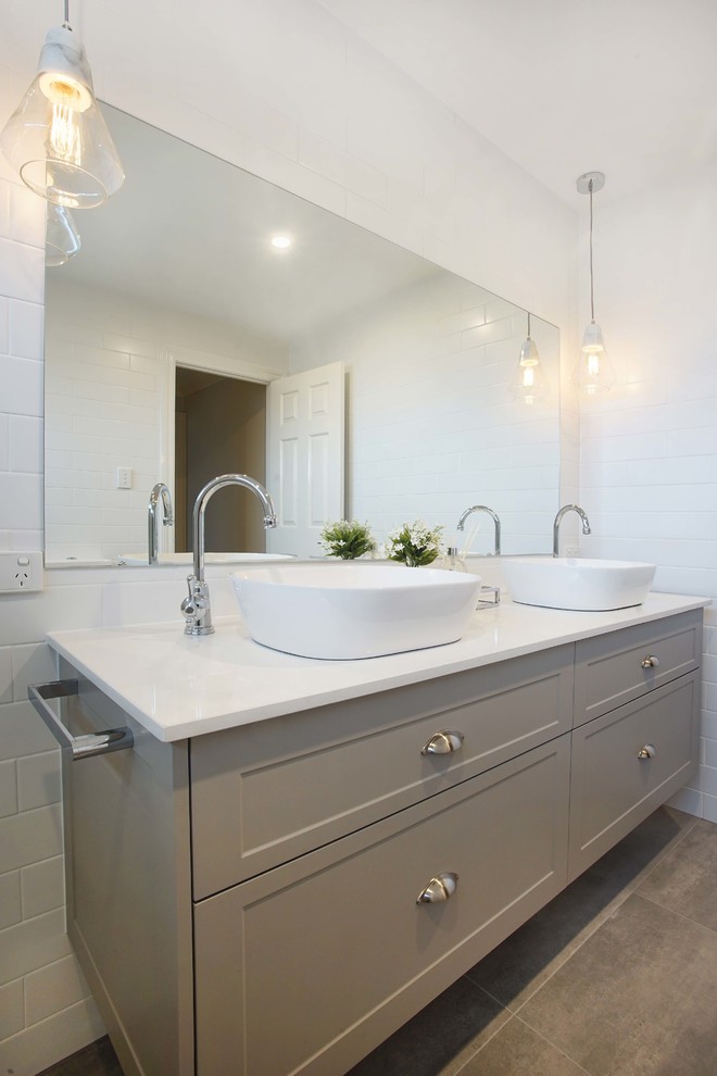 Exemple d'une salle de bain tendance de taille moyenne avec une douche d'angle, un carrelage métro, un sol en carrelage de céramique, une vasque et une cabine de douche à porte battante.