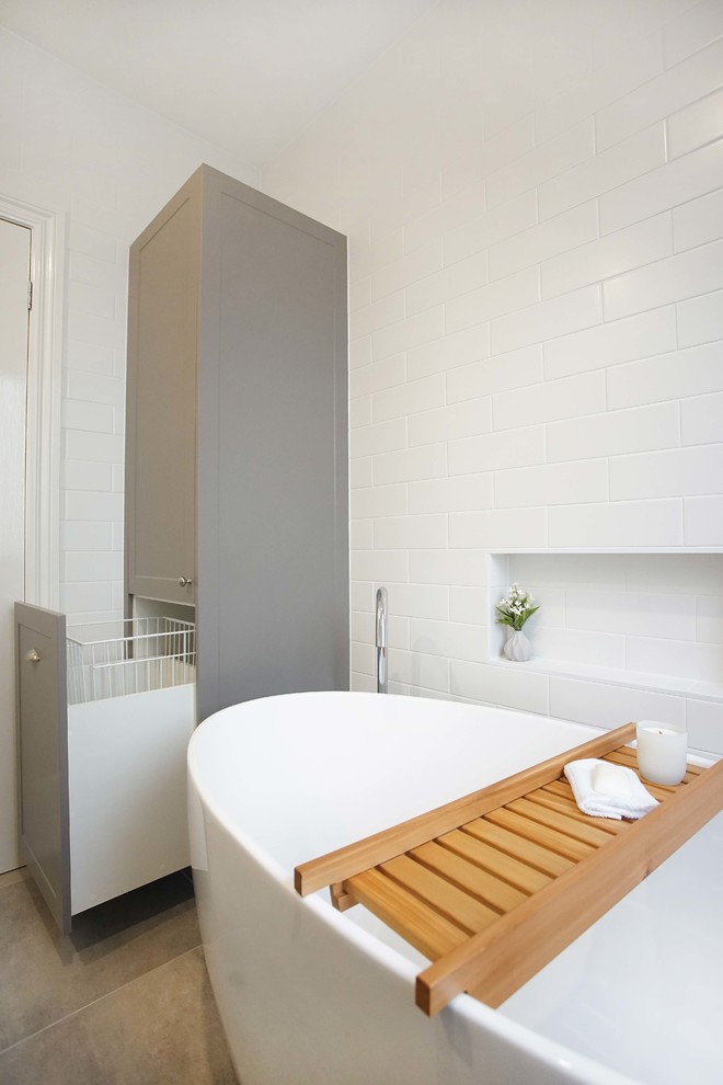 This is an example of a medium sized contemporary bathroom in Melbourne with ceramic flooring, a freestanding bath, metro tiles and white walls.