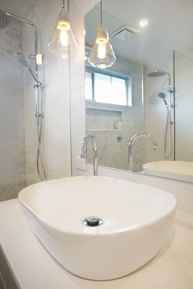 This is an example of a medium sized contemporary bathroom in Melbourne with a corner shower, metro tiles, ceramic flooring, a vessel sink and a hinged door.