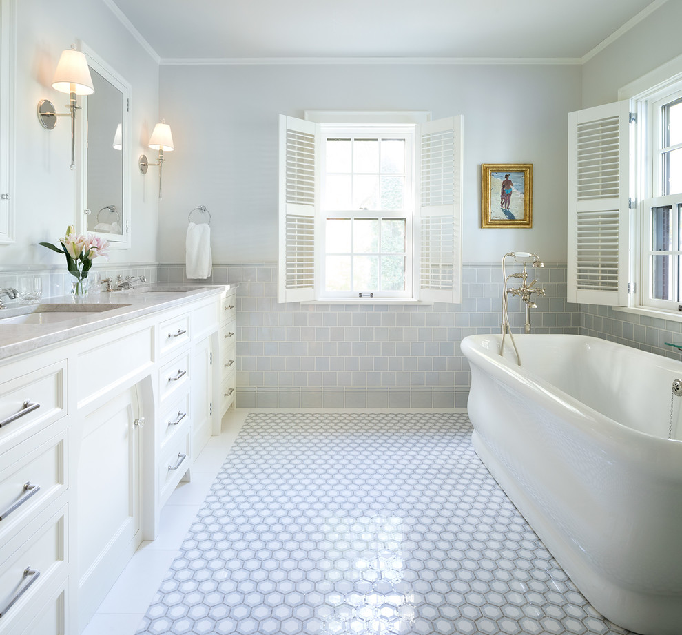 Immagine di una stanza da bagno classica con ante con riquadro incassato, ante bianche, vasca freestanding, piastrelle grigie, pareti grigie, lavabo sottopiano, pavimento grigio e top grigio