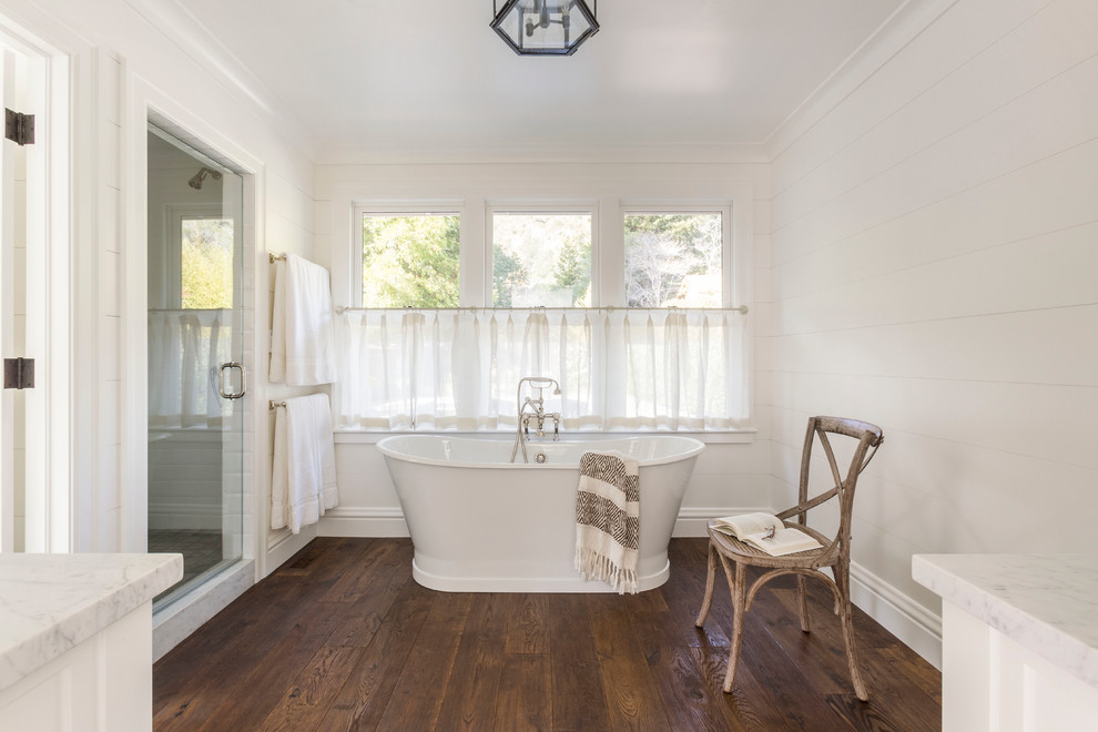Large country ensuite bathroom in San Francisco with shaker cabinets, white cabinets, a freestanding bath, an alcove shower, white tiles, metro tiles, white walls, dark hardwood flooring and a submerged sink.