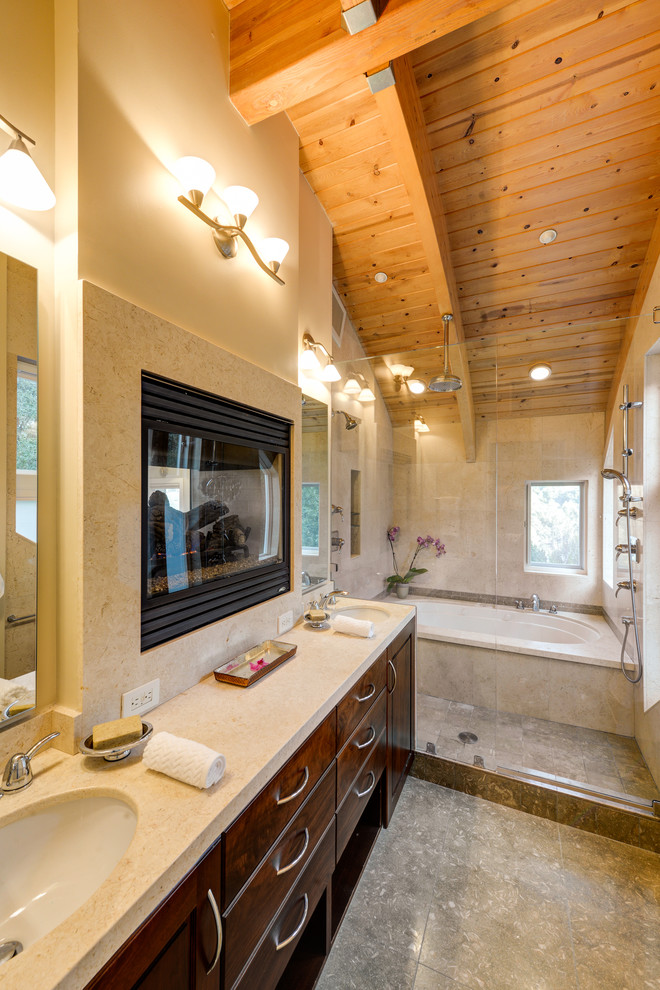 Foto di una stanza da bagno padronale minimal di medie dimensioni con lavabo sottopiano, ante in legno scuro, top in pietra calcarea, vasca sottopiano, doccia doppia e pavimento in pietra calcarea