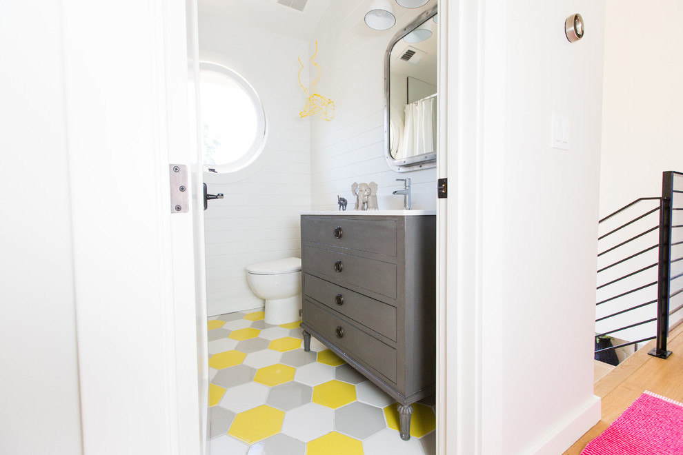 Exemple d'une salle de bain grise et jaune chic pour enfant avec des portes de placard grises, un mur blanc, un sol en carrelage de terre cuite, un sol multicolore et un placard à porte plane.