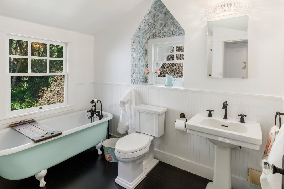 Transitional dark wood floor and brown floor claw-foot bathtub photo in San Francisco with white walls and a pedestal sink