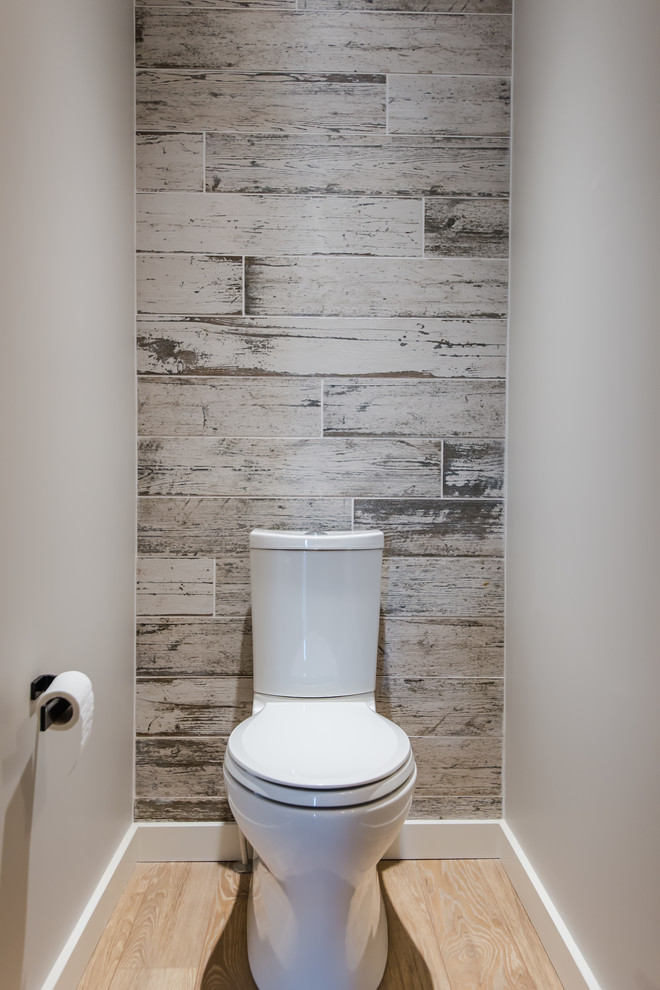 Mid-sized trendy black and white tile and porcelain tile light wood floor powder room photo in Calgary with a two-piece toilet