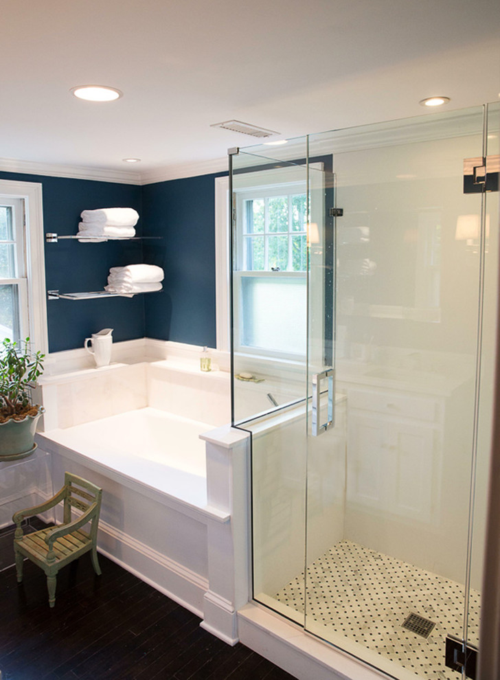 Klassisk inredning av ett mellanstort en-suite badrum, med vit kakel, mörkt trägolv, en dusch i en alkov, blå väggar, ett badkar i en alkov, luckor med infälld panel, vita skåp, stenhäll och ett undermonterad handfat