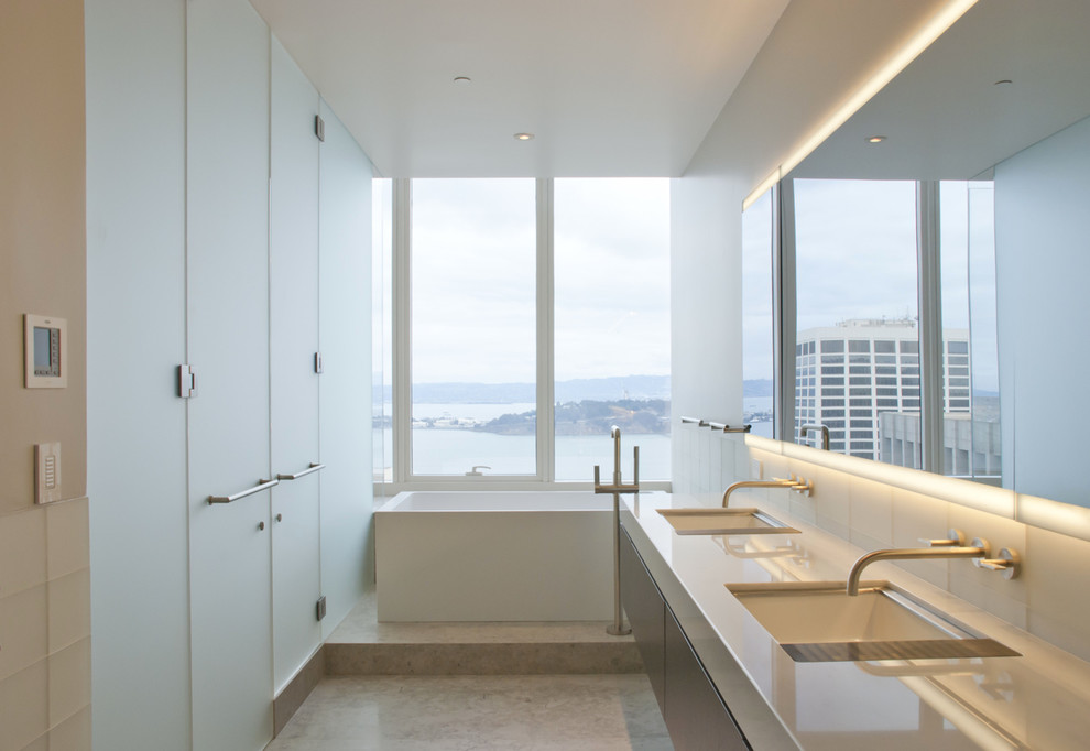 Exemple d'une grande salle de bain principale moderne en bois foncé avec un placard à porte plane, une baignoire indépendante, un carrelage bleu, un carrelage en pâte de verre, un mur beige, un sol en marbre, un lavabo encastré, un plan de toilette en marbre et un sol blanc.