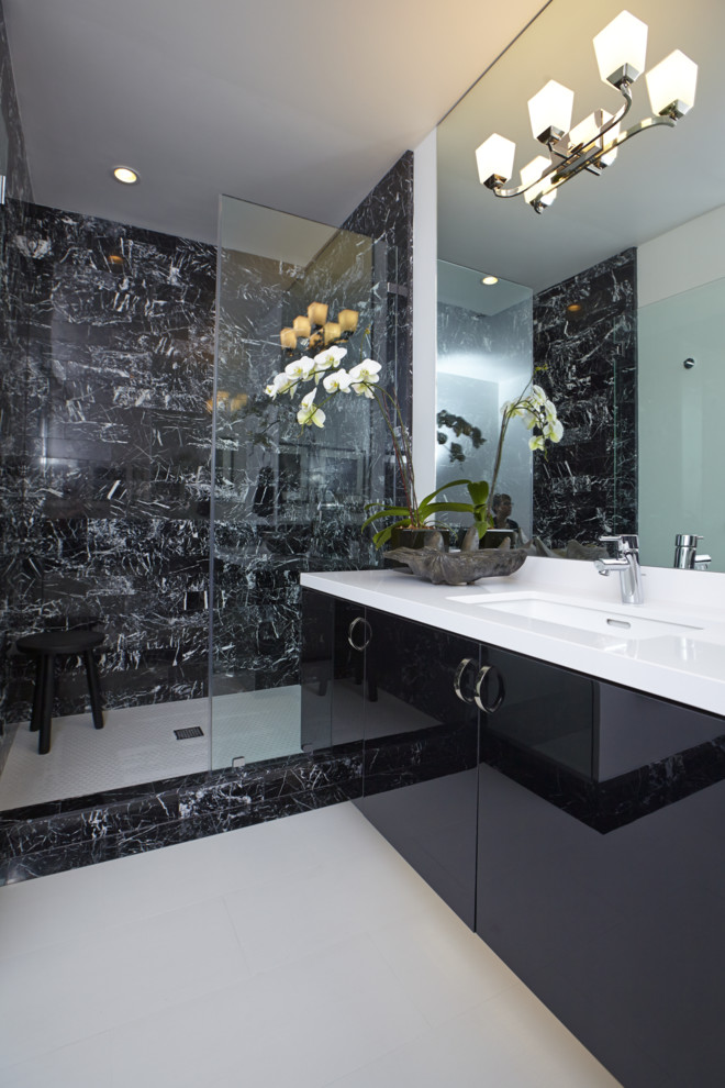 На фото: ванная комната в стиле модернизм с врезной раковиной, плоскими фасадами, черными фасадами, душем в нише, черной плиткой, каменной плиткой и черными стенами
