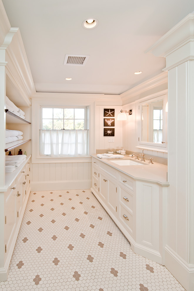 Cette image montre une grande salle de bain principale chalet avec un plan vasque, des portes de placard blanches, un placard avec porte à panneau encastré, un carrelage blanc, un mur blanc et un sol en carrelage de terre cuite.
