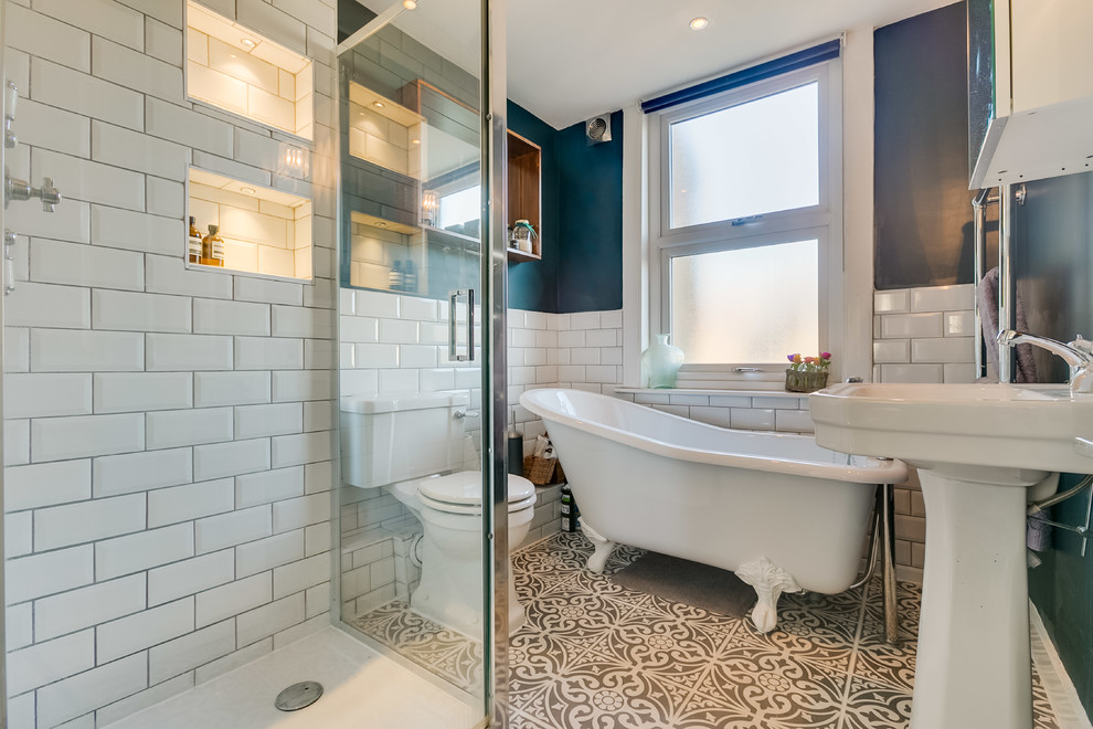 Immagine di una stanza da bagno design di medie dimensioni con vasca freestanding, doccia aperta, piastrelle in ceramica, pareti blu, pavimento con piastrelle in ceramica, lavabo a colonna, pavimento beige e nicchia