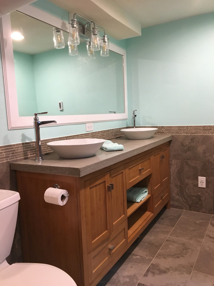 Пример оригинального дизайна: большая главная ванная комната в стиле модернизм с фасадами в стиле шейкер, фасадами цвета дерева среднего тона, отдельно стоящей ванной, двойным душем, раздельным унитазом, коричневой плиткой, плиткой из известняка, синими стенами, полом из известняка, настольной раковиной, столешницей из бетона, коричневым полом, душем с раздвижными дверями и серой столешницей