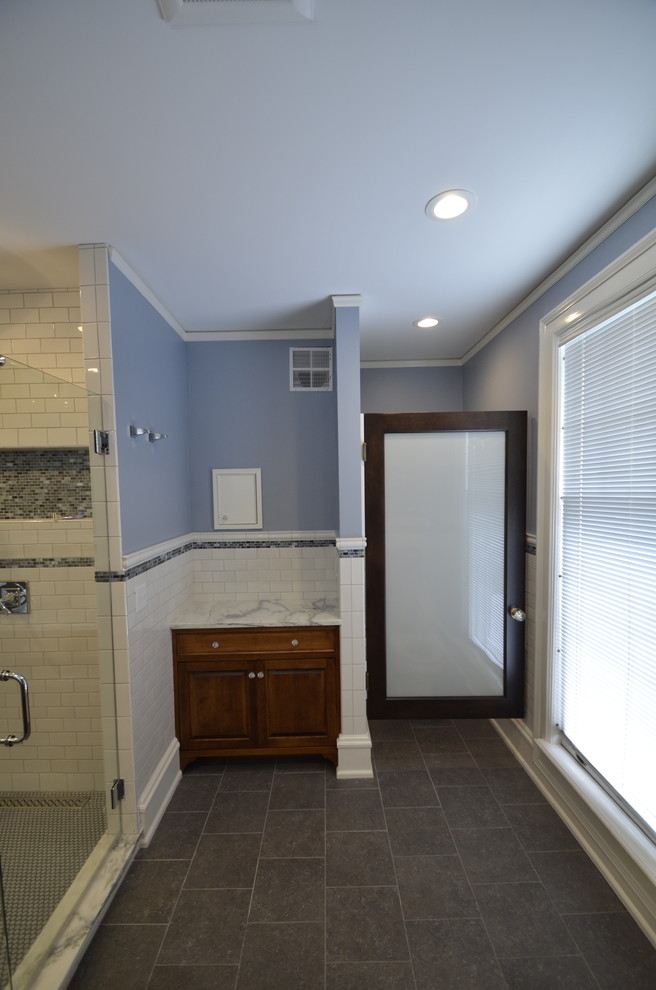 Imagen de cuarto de baño principal clásico con armarios tipo mueble, puertas de armario con efecto envejecido, encimera de mármol, ducha doble, baldosas y/o azulejos grises y paredes azules