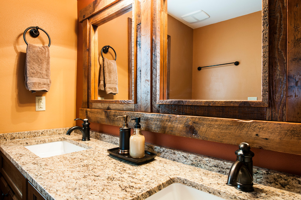 Exemple d'une douche en alcôve principale montagne en bois brun de taille moyenne avec un lavabo encastré, un placard à porte shaker, un plan de toilette en granite, WC à poser, un carrelage beige, des carreaux de céramique, un mur orange et un sol en carrelage de porcelaine.